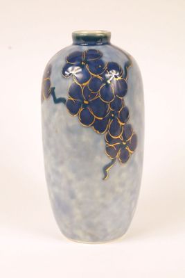 a blue vase with a bunch of grapes on it