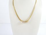 a gold chain necklace with a diamond clasp on a mannequin head