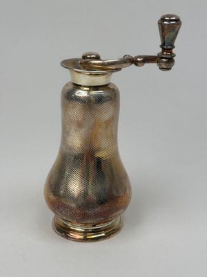 un moulin à café ancien plaqué argent sur fond blanc