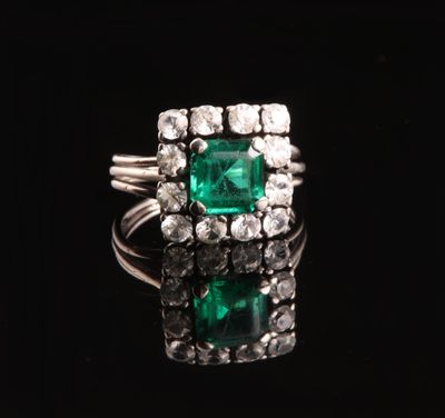 une bague en émeraude et diamant sur une surface noire