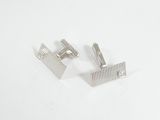 une paire de boutons de manchette en argent sur une surface blanche, sur fond blanc