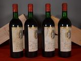 three bottles of red wine sit on a table next to a wooden box