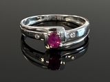 an image of a ruby and diamond ring on a black surface