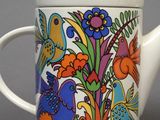 a white tea pot with colorful flowers and birds on it
