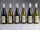 six bouteilles de vin sont alignées sur une table