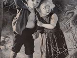 two children that are standing in the snow together