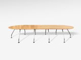 une table de réunion ovale à quatre pieds, avec un plateau en bois