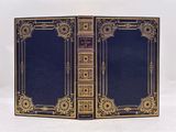 un vieux livre ouvert, dévoilant une couverture bleue rehaussée de dorures