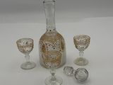 three glasses and a decanter sitting on a table