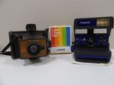 a polaroid camera sitting next to a polaroid film camera