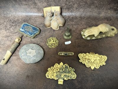 several pieces of antique brass are on a table next to a coin