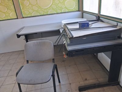une image représentant un bureau avec une chaise et une pile de papiers