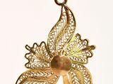 a gold pendant with a butterfly on it