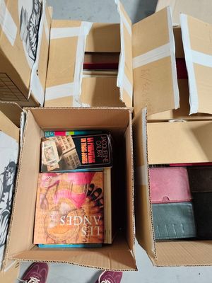 two boxes of books and a pair of shoes on the floor