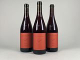 three bottles of wine sitting on top of a white surface