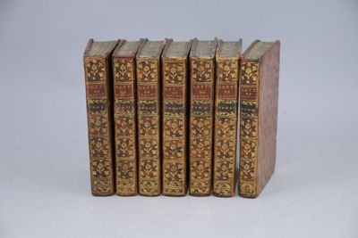 quatre vieux livres sont alignés sur une surface blanche