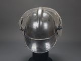 an old helmet on a stand on a gray background