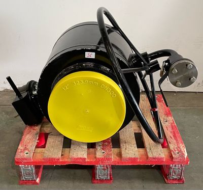 a large black barrel on a pallet with a yellow wheel