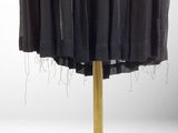 a black skirt on a gold stand on a white background