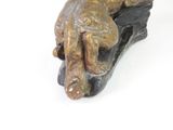 a statue of a dog laying on top of a shoe