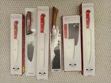 three knives are sitting in a box on a white surface