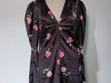 une robe posée sur un mannequin, ornée d'un motif de roses
