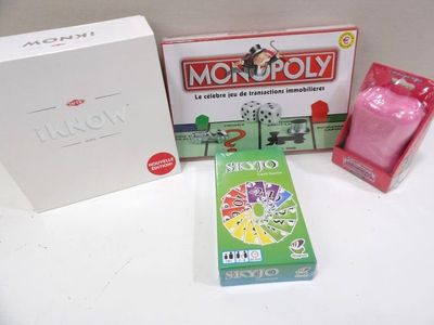 une boîte de Monopoly et un jeu de cartes posés sur une table