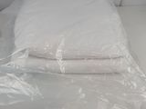 a white bed with two pillows and a pillow on it