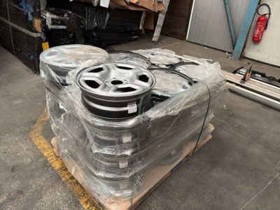 a lot of wheels sitting on a pallet in a warehouse