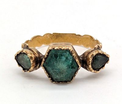 une image d'une bague en or avec une pierre verte