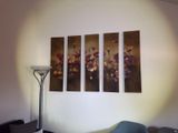 three paintings hanging on the wall above a bed