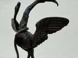 a statue of a bird on a rock with its wings spread