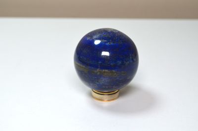 une photo d'une bille bleue posée sur une surface blanche