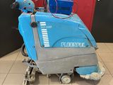 the floor scruber is sitting on the tiled floor in front of a red door