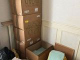 une pile de cartons posée par terre dans un coin de la pièce