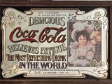 une photo encadrée représentant une publicité pour Coca-Cola accrochée au mur