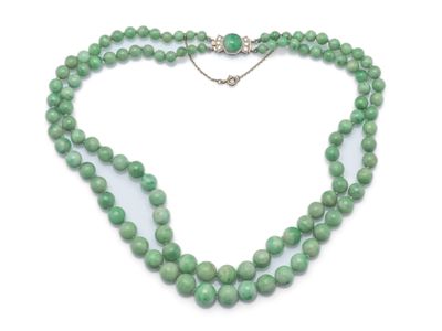gros plan d'un collier de perles vertes sur fond blanc