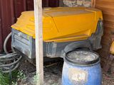 un camion jaune garé à côté d'un fût bleu