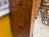 une armoire en bois surmontée d'un tiroir, dans une pièce