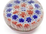 a glass paperweight with red, white, and blue flowers on it