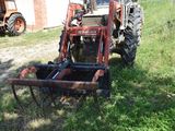 a tractor that is sitting in the grass near a building