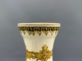 un vase blanc orné d'un motif doré