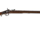 un fusil au canon en bois et aux garnitures en laiton, sur fond blanc