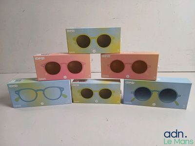 six paires de lunettes sont posées sur une table devant une boîte