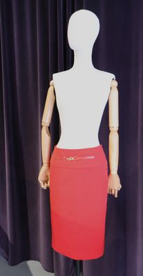 un mannequin vêtu d'une jupe rouge, posé sur un pied de mannequin