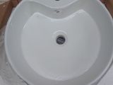 a white sink sitting on a cardboard box in a room