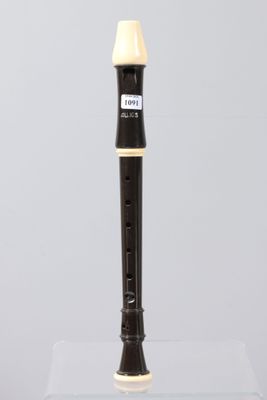 a close up of a black and white flute on a clear surface