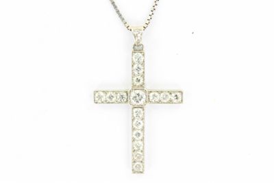 un pendentif en forme de croix en diamant, suspendu à une chaîne, sur fond blanc