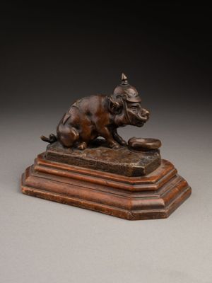 statue en bronze représentant un chien sur un socle, tenant un livre