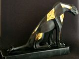 statue of an egyptian cat sitting on top of a black base